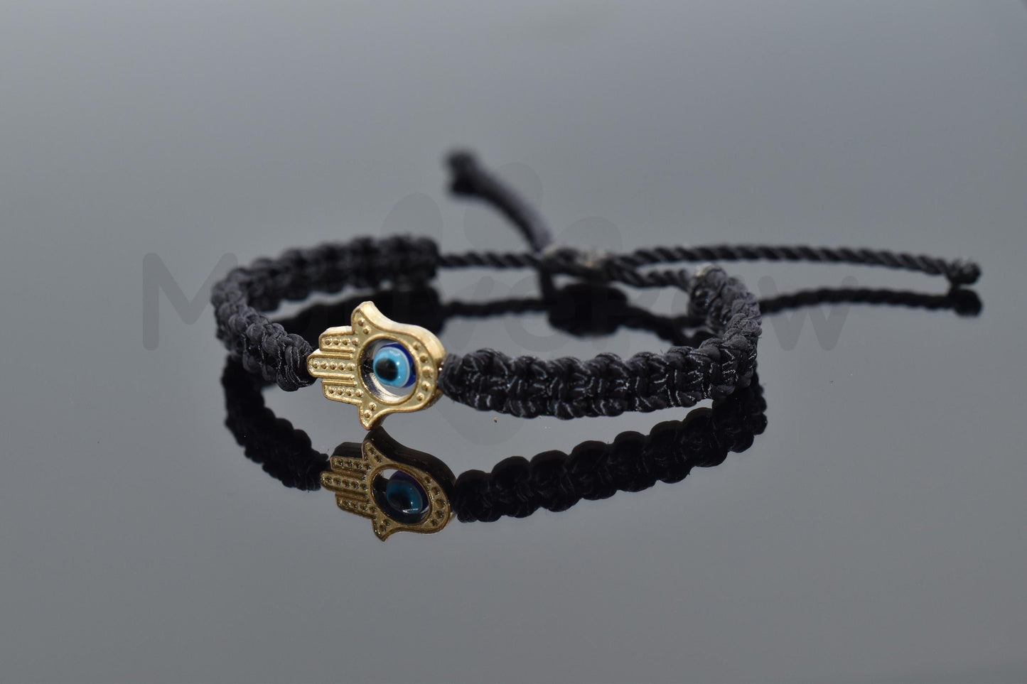 kids size Hamsa hand bracelet with an evil eye for protection & good luck, braided black string wristband with a gold color hamsa hand